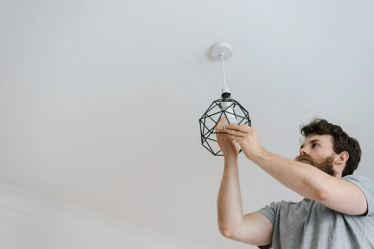 Electricista instalando iluminación LED en la zona común de una comunidad de vecinos en Canarias